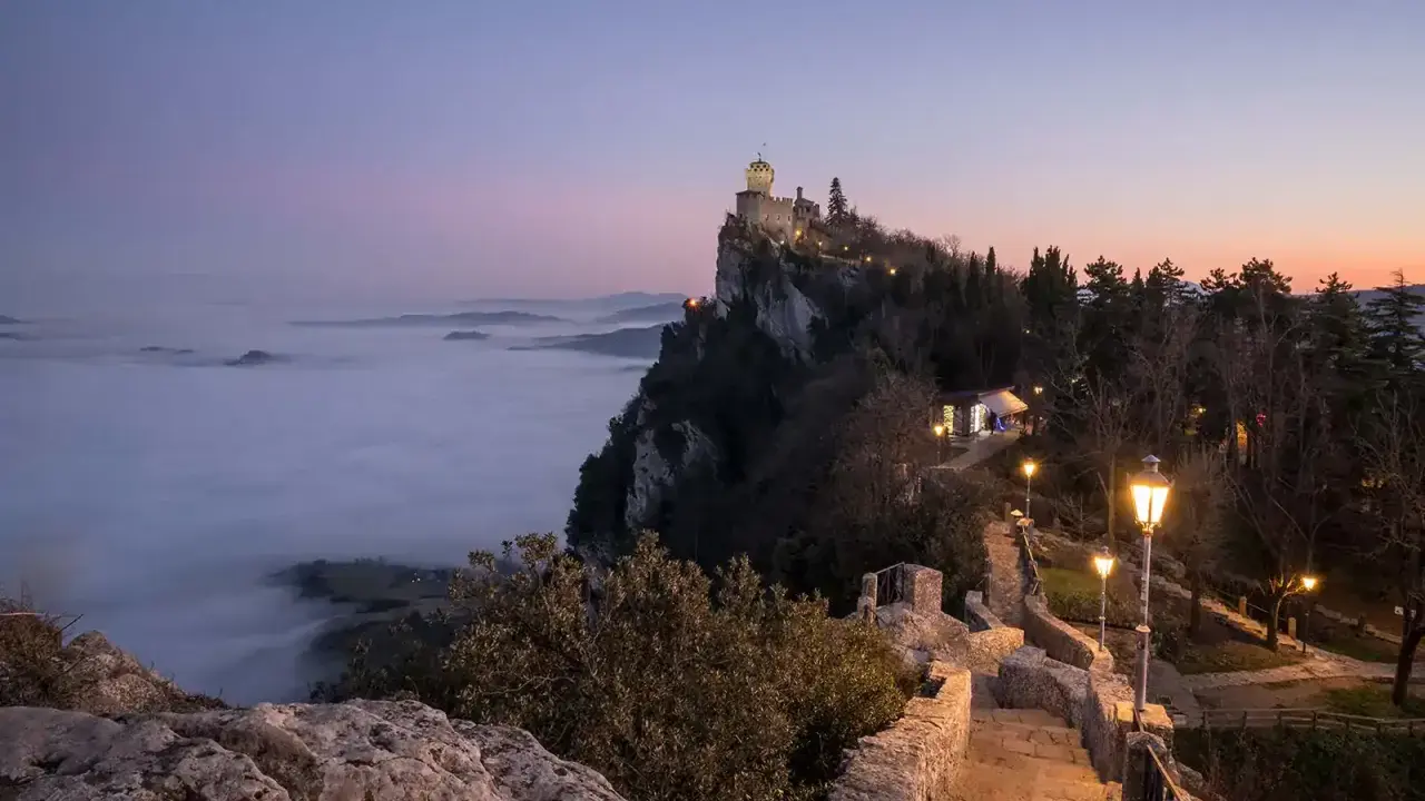 Torre Guaita domina la nebbia al tramonto, un luogo magico dove si trova San Marino.