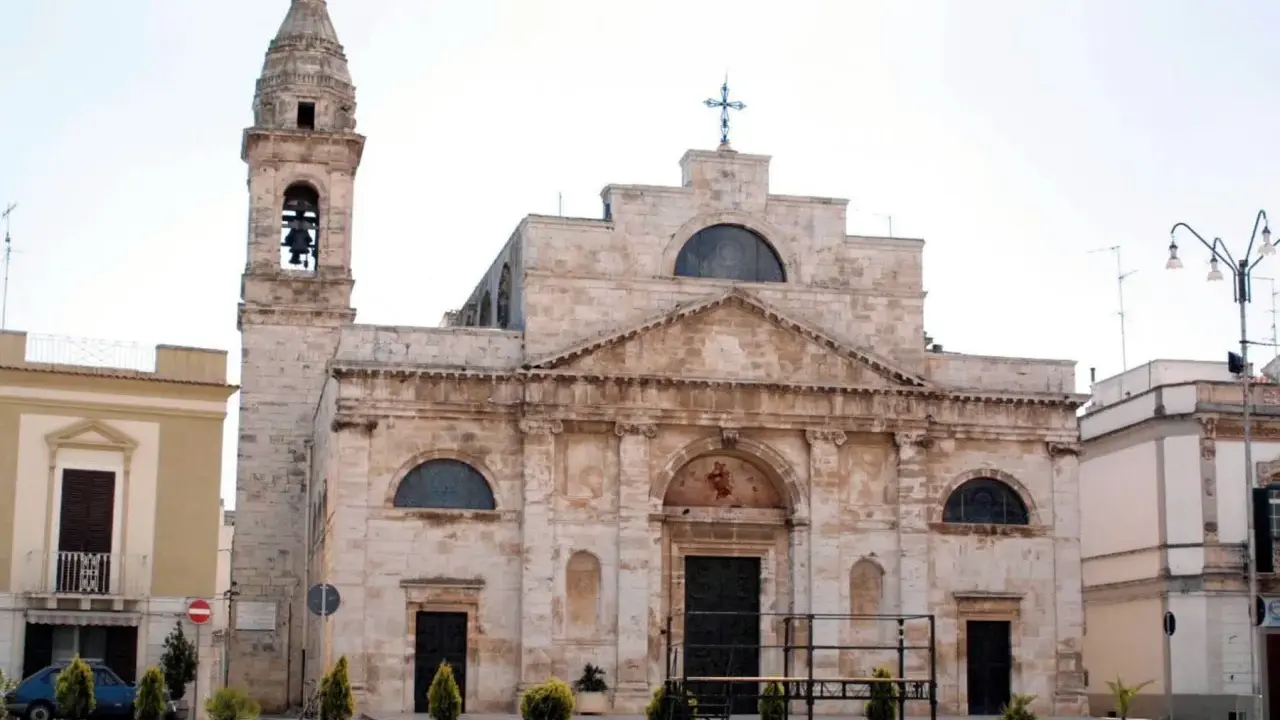 La Cattedrale di San Michele Arcangelo a Sammichele di Bari, con il suo imponente campanile e la facciata in pietra chiara, domina la piazza.