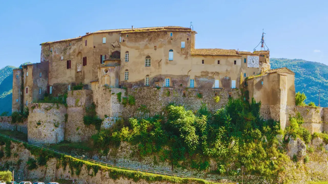 Antico castello su una collina, uno dei borghi medievali vicino Roma, con un grande orologio sulla torre.
