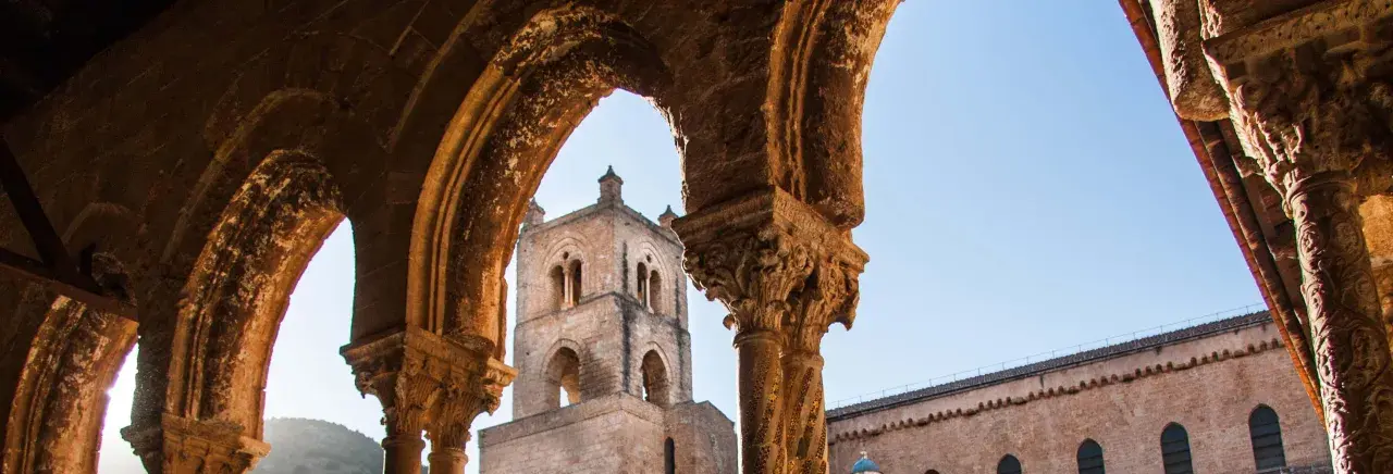 Archi decorati e campanile del Duomo di Monreale, un luogo imperdibile da vedere in Sicilia.