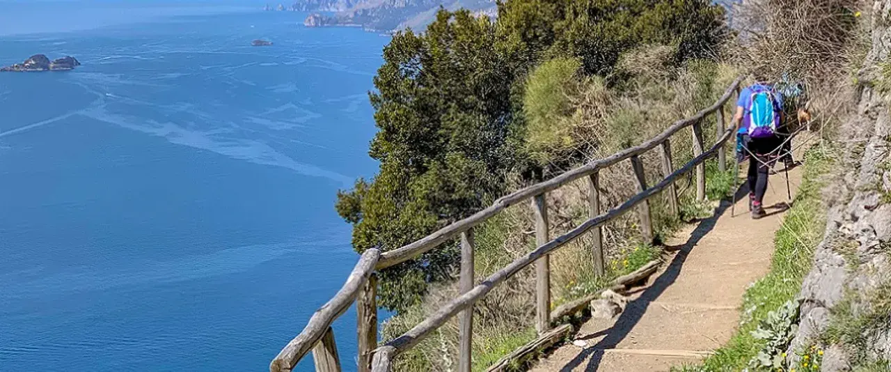 Escursionista sul sentiero degli dei ad Agerola, con vista mozzafiato sul mare blu e le isole.