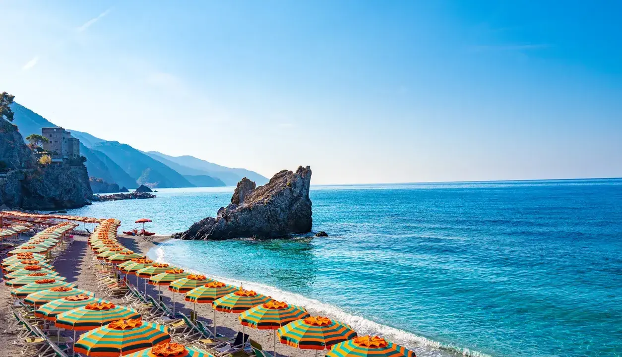Spiaggia con ombrelloni colorati e mare cristallino, un angolo di paradiso, il mare più vicino a Milano.
