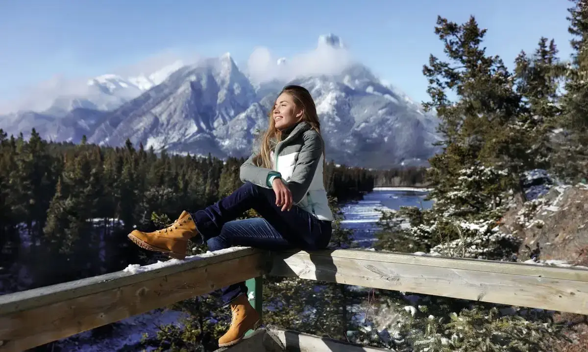 Ragazza con gita outfit montagna estate, gode del panorama innevato.