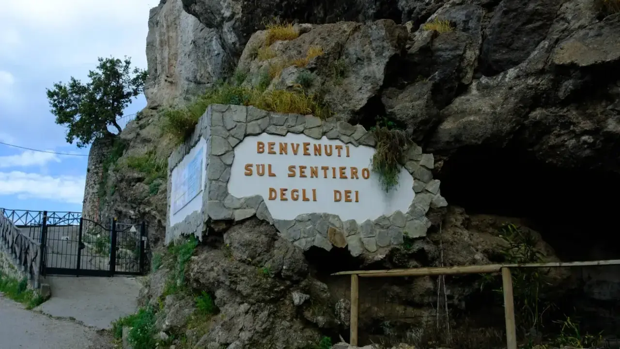 Ingresso del Sentiero degli Dei, con cartello di benvenuto e cancello in ferro battuto.