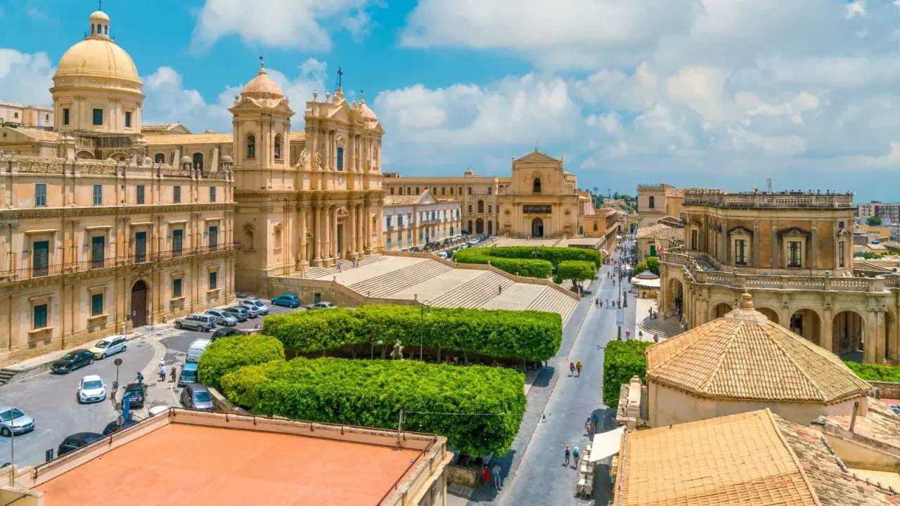 Vista aerea di un noto borgo della costiera amalfitana, con chiese barocche, piazze e strade animate.