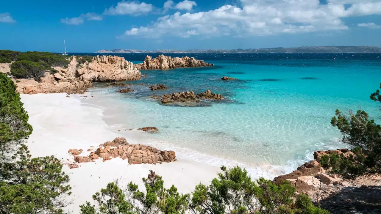 Spiaggia bianca, rocce rosse e mare cristallino: un sogno per chi cerca dove andare al mare a settembre spendendo poco.