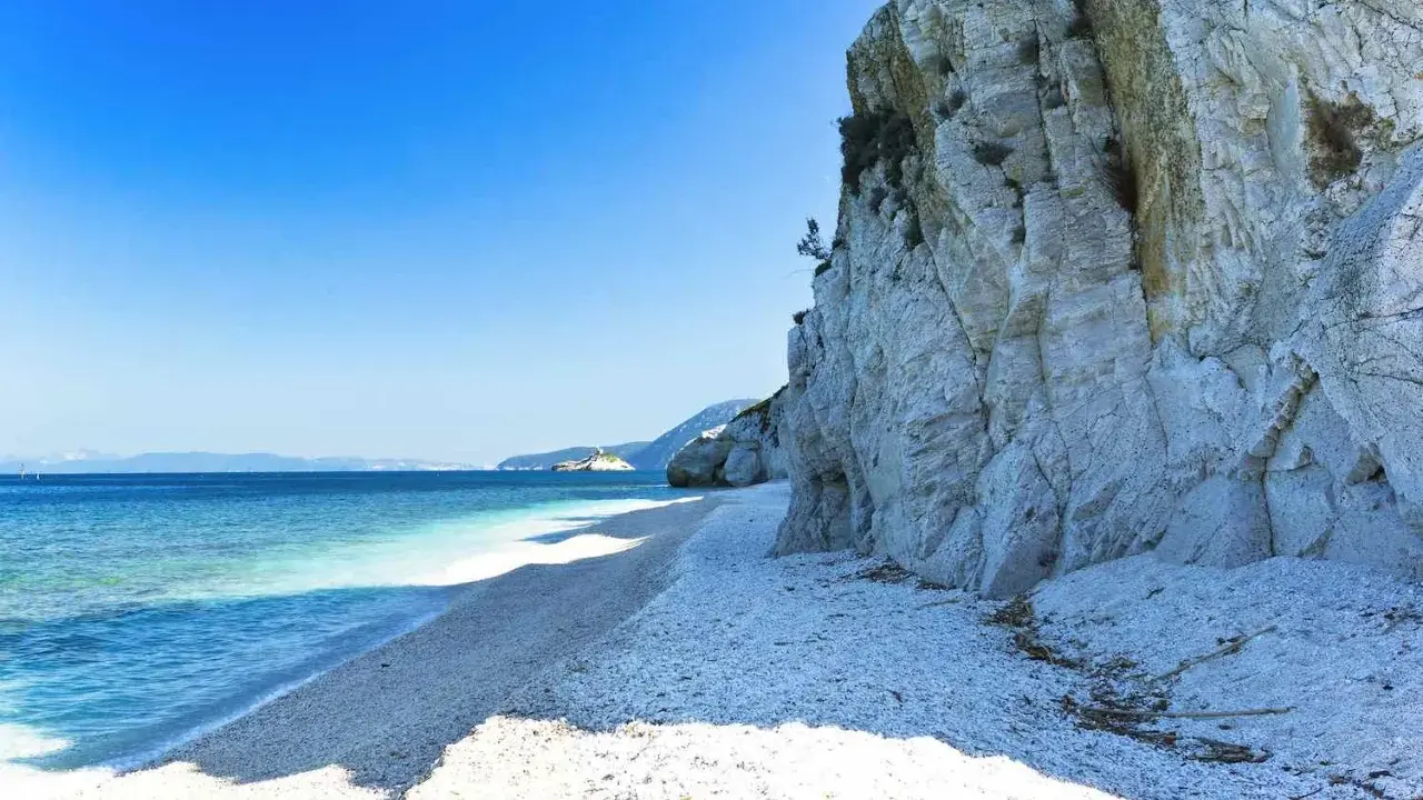 Scogliera bianca a picco sul mare cristallino, un angolo di paradiso tra le spiagge più belle dell'Isola d'Elba.