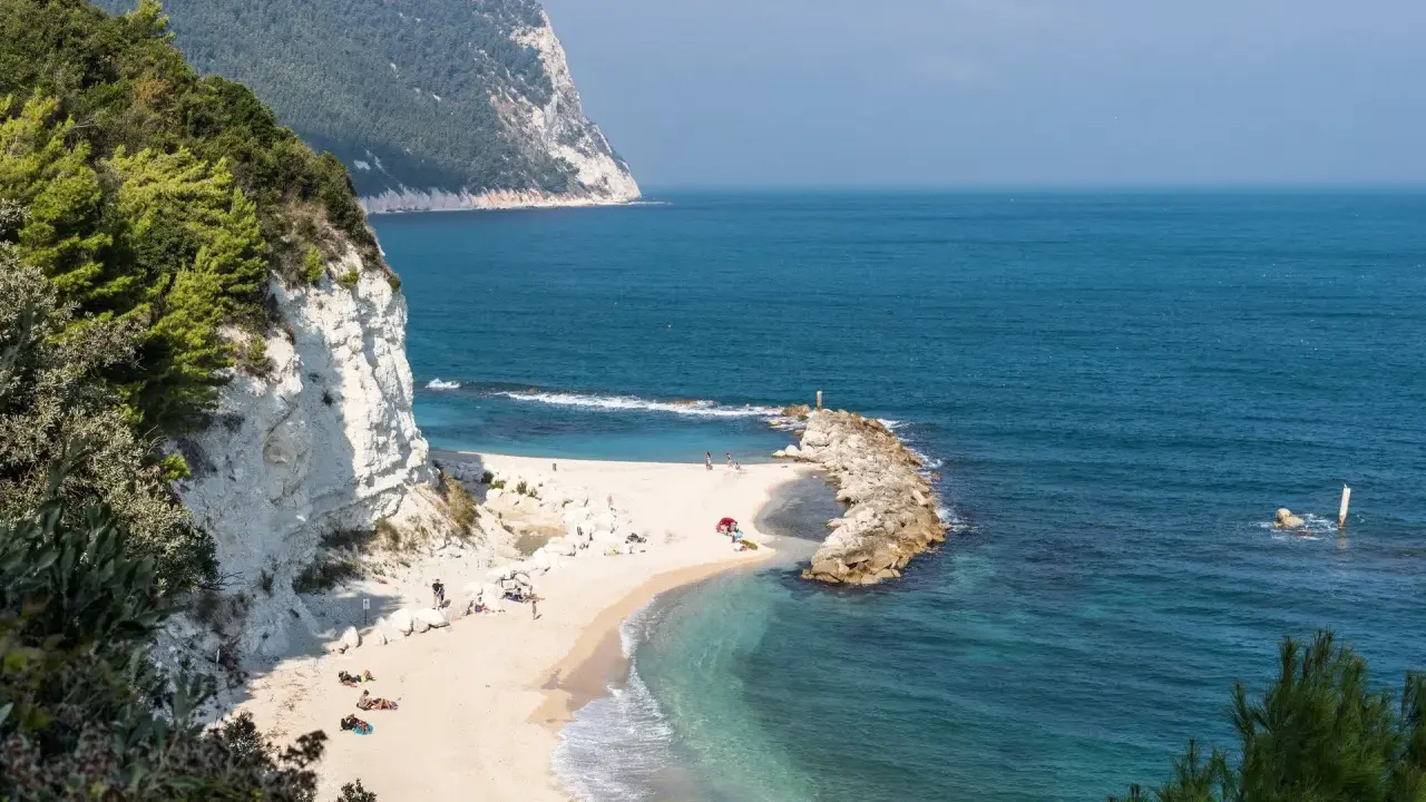 Spiaggia dorata con scogliere bianche e mare cristallino, un angolo di paradiso tra le migliori spiagge del nord Italia.