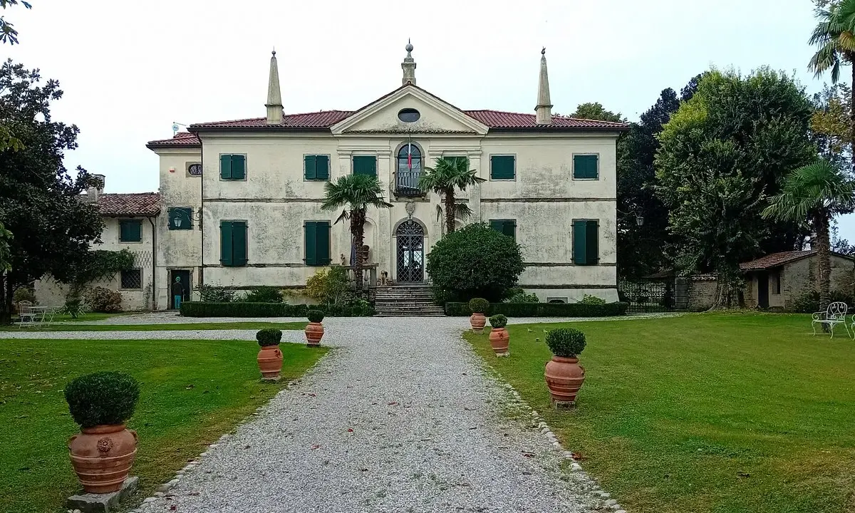 Villa storica con viale di ghiaia e vasi decorativi. Un luogo incantevole per scoprire cosa vedere a Clauiano.