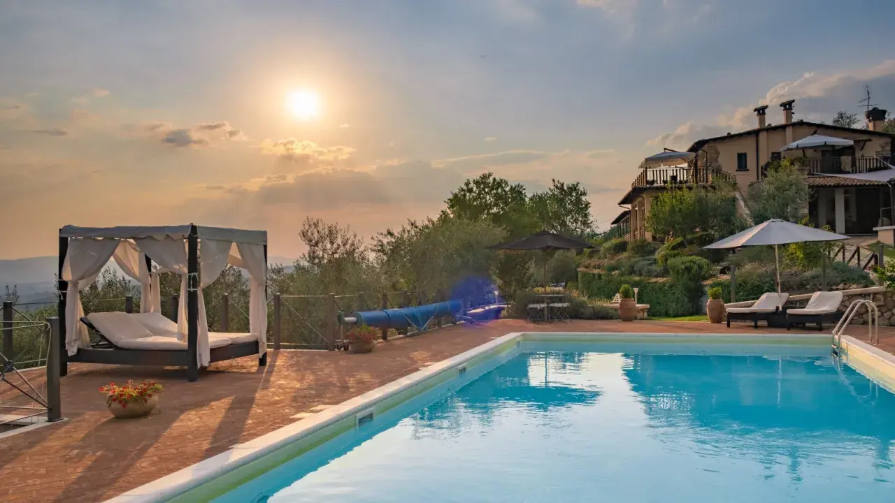 Piscina e lettini in una delle splendide tenute in Toscana al tramonto.