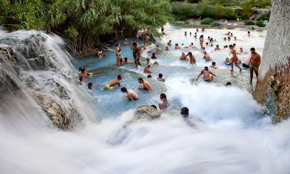 Cascate naturali con persone che si bagnano, un luogo incantevole dove si trovano le terme di Saturnia.