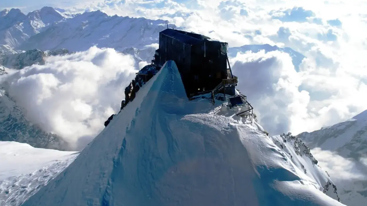 Il rifugio più alto d'Italia, incastonato su una vetta innevata, domina un mare di nuvole.