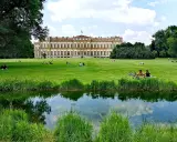 Villa Reale di Monza e il suo parco: un'idea per cosa vedere a Monza in un giorno. Persone rilassate sull'erba, un laghetto e il maestoso edificio.
