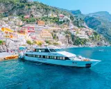 Il Positano Jet attracca al molo, con le case colorate della Costiera Amalfitana sullo sfondo.