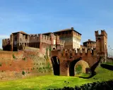 Castello Sforzesco, uno dei borghi belli vicino Cremona, con mura in mattoni rossi, ponti ad arco e fossato verde.