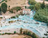 Una perfetta gita domenicale toscana: cascate termali azzurre e gente che si rilassa tra le rocce.