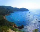 Cala Grande Argentario: un paradiso azzurro con barche. Per arrivare, goditi questo panorama mozzafiato.