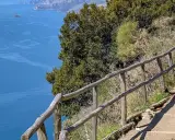 Escursionista sul sentiero degli dei ad Agerola, con vista mozzafiato sul mare blu e le isole.