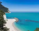 Spiagge piu belle d'Italia: una caletta di sabbia bianca incastonata tra scogliere a picco e un mare turchese cristallino.