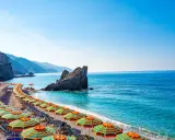 Spiaggia con ombrelloni colorati e mare cristallino, un angolo di paradiso, il mare più vicino a Milano.