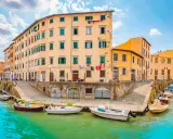 Canali di Livorno, un'idea per cosa vedere a Livorno in un giorno. Case colorate e barche sull'acqua turchese.