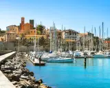Porto turistico con barche a vela ormeggiate e case colorate che si affacciano sul mare, nel cuore del talamone centro storico.