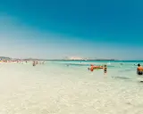 Acque cristalline e gente felice in spiaggia, forse qual è la parte più bella della Sardegna? Un paradiso azzurro.
