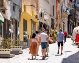 Passeggiata in un vicolo di Procida, tra negozietti colorati e case bianche. Perfetto per capire come muoversi a Procida a piedi.
