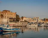 Porto di Favignana con barche ormeggiate e edifici storici. Per sapere come arrivare a Favignana, guarda questo porto!