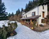 Rifugio Cimon della Bagazza, un luogo accogliente con rifugi aperti in inverno in Lombardia, circondato da neve e alberi.