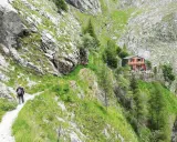 Escursionista sul sentiero della via Vandelli, con rifugio in vista.