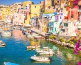 Porto di Corricella a Procida, un gioiello colorato. Ecco cosa vedere a Procida in un giorno: case pastello, barche nel blu intenso e bouganville in fiore.