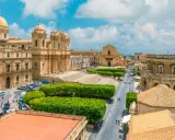 Vista aerea di un noto borgo della costiera amalfitana, con chiese barocche, piazze e strade animate.