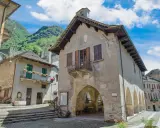 Un borgo antico con case in pietra e balconi fioriti, incastonato tra montagne verdi. Un luogo che fa venire vogogna cosa vedere, per la sua bellezza autentica.