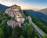 Borgo pittoresco su un colle, ideale per scoprire cose da fare a Varese. Case colorate, un campanile e sentieri panoramici tra il verde.