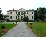 Villa storica con viale di ghiaia e vasi decorativi. Un luogo incantevole per scoprire cosa vedere a Clauiano.