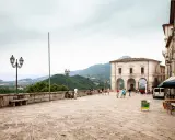 Piazza di Civitella del Tronto con edifici storici, gente che passeggia e vista panoramica sulle colline verdi.
