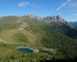 Panorami alpini con sentieri per passeggiate facili vicino a Trento, un lago azzurro e cime rocciose.