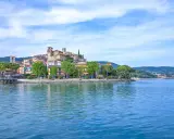 Il borgo più bello del Lago Trasimeno, con le sue case colorate e torri medievali, si specchia nelle acque azzurre.