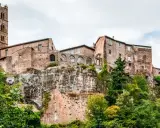 Un borgo medievale arroccato su una rupe, con un'alta torre campanaria. Un esempio dei borghi più belli del Lazio, immerso nel verde.
