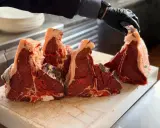 Maneggiare con cura la bistecca fiorentina a Firenze, pronta per essere grigliata.