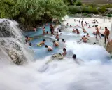 Cascate naturali con persone che si bagnano, un luogo incantevole dove si trovano le terme di Saturnia.