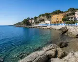 Acque cristalline e case colorate lungo la costa, un angolo di paradiso tra le calette di Porto Santo Stefano.