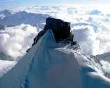 Il rifugio più alto d'Italia, incastonato su una vetta innevata, domina un mare di nuvole.