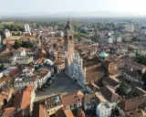 Vista aerea della Duomo di Monza, con la sua facciata a strisce bianche e nere. Si vede il campanile e il centro storico, che mostra dove si trova Monza.