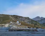 Osservatorio astronomico sul Gran Sasso, con montagne imponenti sullo sfondo. Un luogo ideale per gli alpinisti che amano la natura e il cielo stellato.