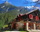 Rifugio con forni di sopra, circondato da boschi e montagne imponenti.