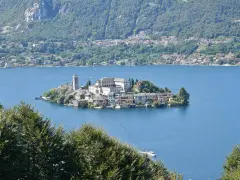 Isola di San Giulio, un gioiello incastonato nel lago d'Orta, Italia. Un borgo pittoresco con un campanile svetta sull'acqua blu.