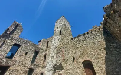 Rovine di un castello nel centro storico di Passignano sul Trasimeno, con mura in pietra e cielo azzurro.