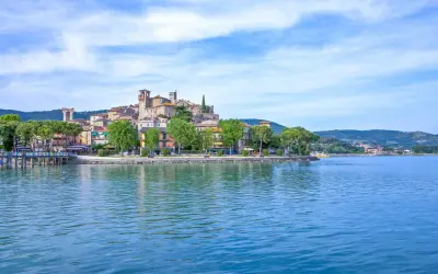 Il borgo più bello del Lago Trasimeno, con le sue case colorate e torri medievali, si specchia nelle acque azzurre.